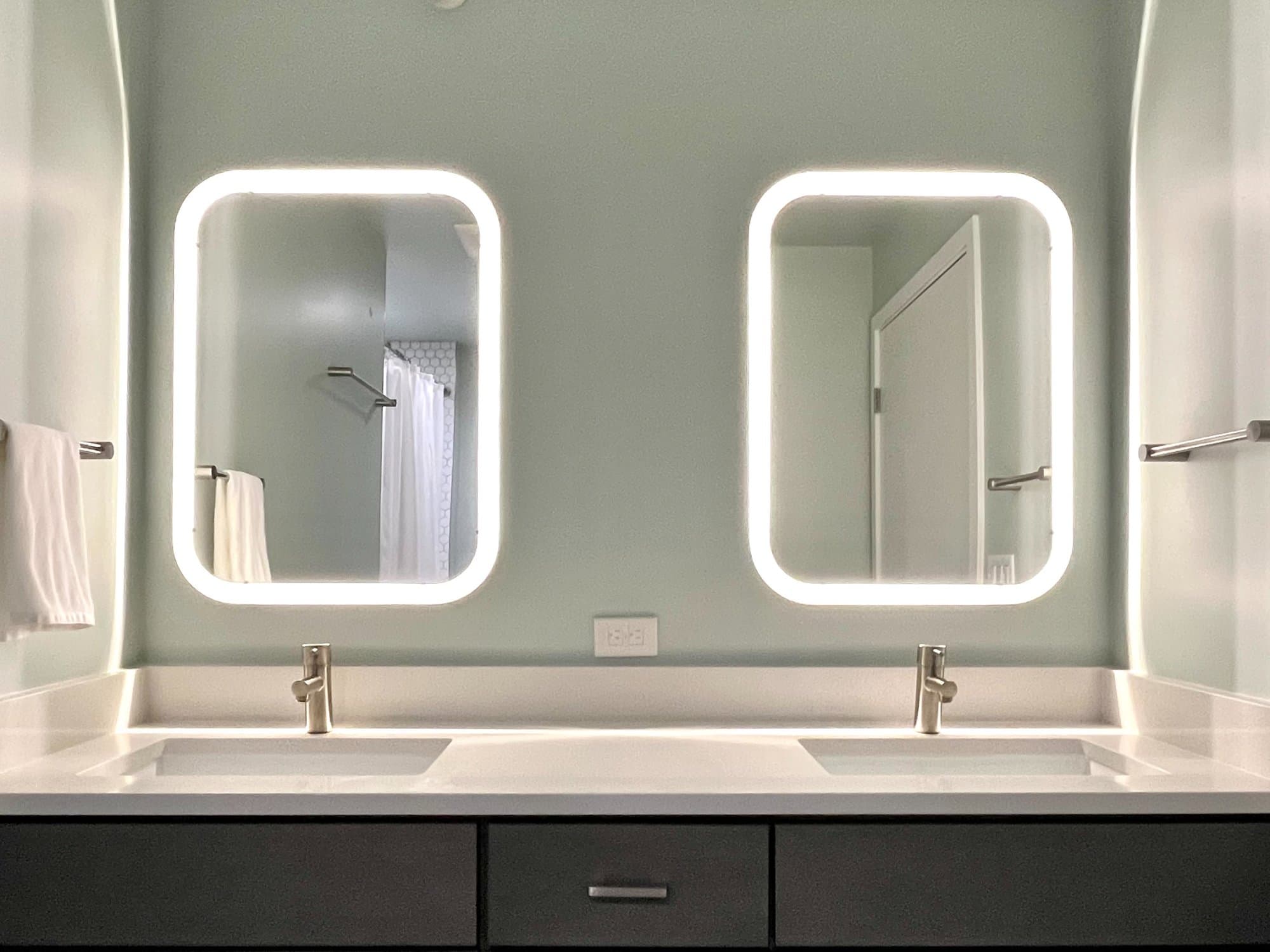 Modern bathroom with double vanity and LED mirrors